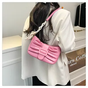 Détail d'un sac à main plissé rose orné d'un foulard en soie imprimé sur la bandoulière