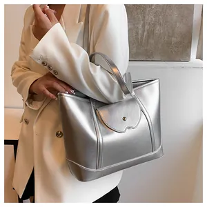 Close-up of silver metallic tote bag with natural texture and curved front pocket