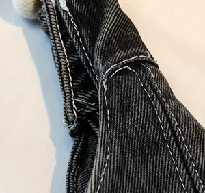 Macro shot of precision white stitching on premium black denim shoulder bag strap