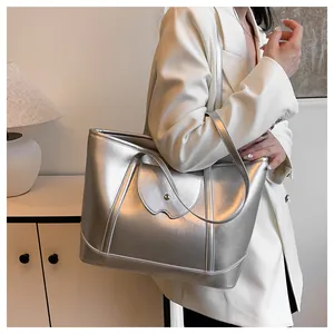 Silver metallic tote bag shown on a model featuring large capacity and stylish buckle