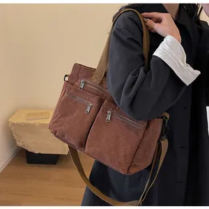 Brown corduroy crossbody bag with multiple pockets and adjustable strap shown on model