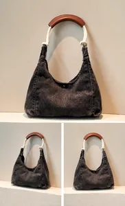 Detailed macro view of denim hobo bag featuring contrast stitching and rope shoulder strap