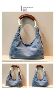 Detail view of light blue denim crescent bag with knotted rope strap and leather handle
