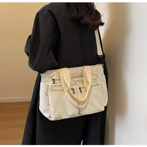 Detail of off-white corduroy tote showing multiple pockets and textured fabric material