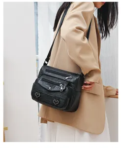 Detailed view of black vintage PU leather crossbody bag with multiple zipper pockets