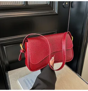 Vue détaillée de la texture en peau de serpent rouge vif sur un sac à rabat élégant
