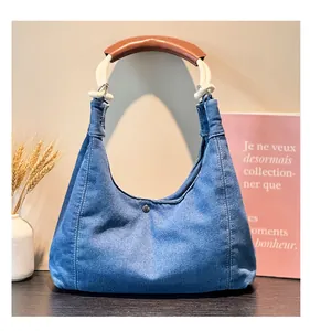 Detailed close-up of blue denim bag with white cotton rope handle and brown leather grip