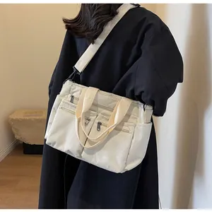 Detail of corduroy tote bag with dual front zippers and detachable shoulder strap