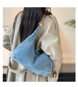 Detail of blue denim hobo bag featuring soft texture and stylish metallic hardware