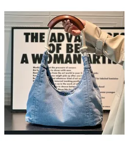 Detail of light blue denim tote bag with unique woven rope and brown leather handle