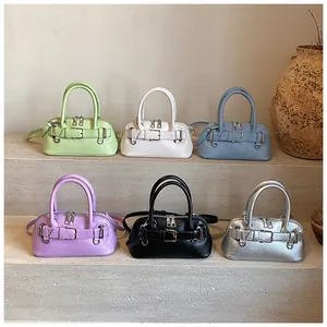 Collection of colorful shell bags in six diverse shades on a minimalist stone display