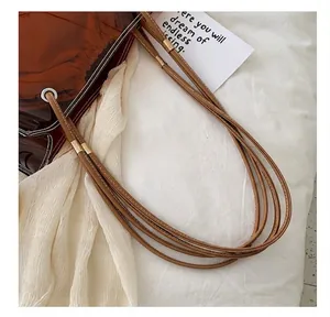 Detail der braunen transparenten PVC-Tasche mit Ziernähten und goldenen Metallbeschlägen