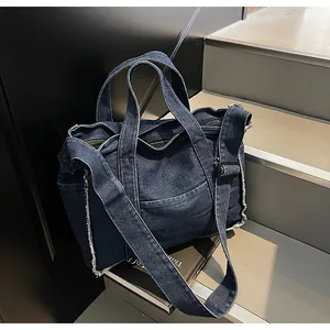 Detailed macro view of deep blue denim tote bag with frayed edges and adjustable strap