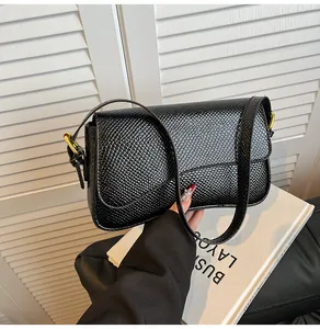 Gros plan du sac baguette noir en cuir PU avec texture serpent et boucle en métal doré