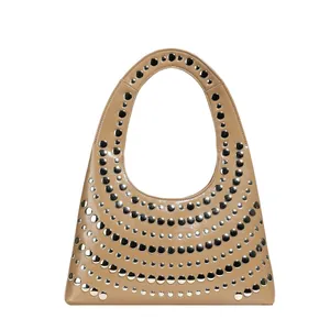 Chic tan leather tote bag with silver metal eyelet studs and integrated handle