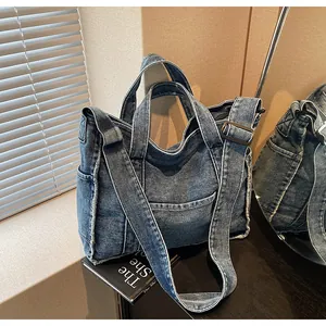 Detailed close-up of retro blue denim tote bag with frayed edges and textured fabric