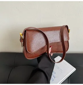 Détail du sac bandoulière marron texture lézard avec boucle en métal doré élégante