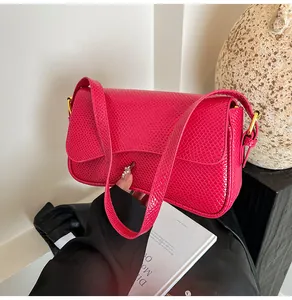 Détail du sac fuchsia à relief peau de reptile avec boucle dorée en métal poli