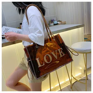 Brown transparent PVC tote bag with LOVE text and drawstring inner pouch shown on shoulder