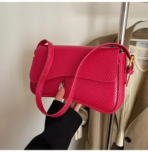 Détail du sac à bandoulière en cuir gaufré rose rouge avec boucle en métal doré