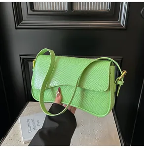 Détail de la texture serpent vert citron et de la boucle dorée du sac à bandoulière