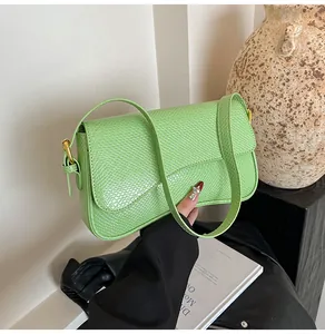 Détail du sac à bandoulière en similicuir serpent vert clair avec boucle dorée