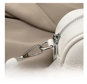 Macro shot of silver hardware hook and zipper on white lychee pattern Boston bag