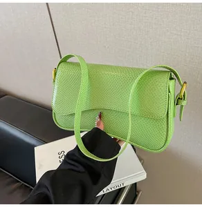Détail du sac vert vif à texture crocodile avec fermoir en métal doré et bandoulière