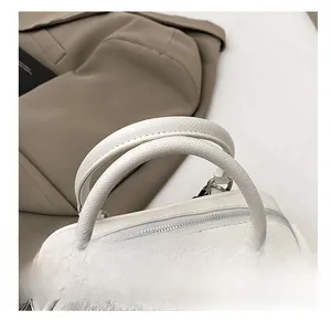 Detail of white lychee pattern Boston bag showing soft handles and metal zipper