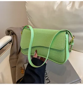 Détail du sac à bandoulière vert vif avec gaufrage crocodile et fermoir en métal doré