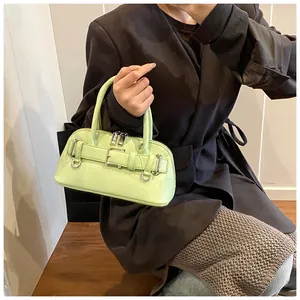 Detail of light green shell bag with decorative buckle and litchi texture on leather