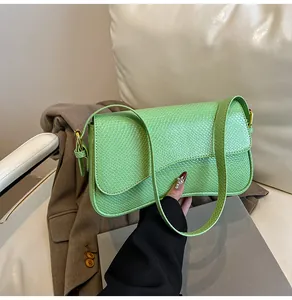 Détail de la texture crocodile vert clair et des boucles dorées du sac baguette