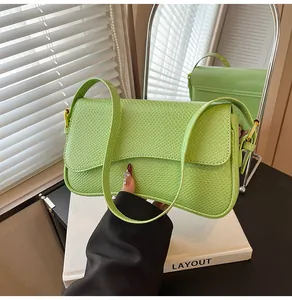 Détail du sac à bandoulière en similicuir vert clair avec texture peau de serpent