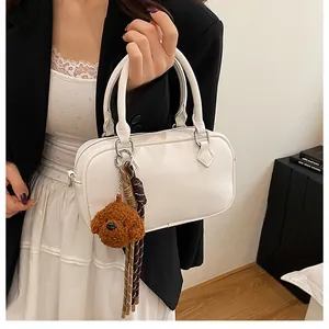White Boston bag in lychee pattern leather featuring a cute teddy bear charm and tassels