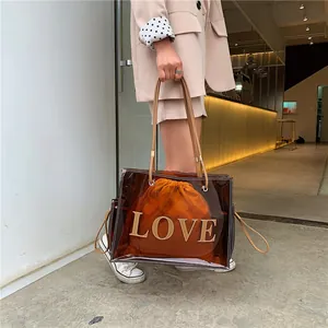 Brown transparent PVC tote bag with LOVE appliqué and orange drawstring pouch