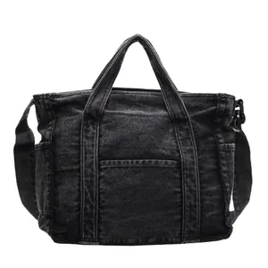 Black washed denim tote bag with adjustable shoulder strap and utility pockets