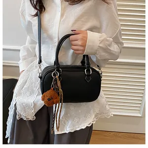 Litchi pattern black Boston bag with teddy bear charm and contrast white stitching