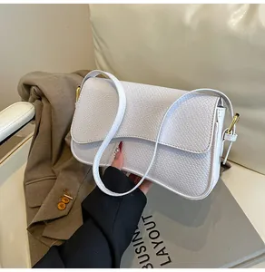 Vue détaillée d'un sac bandoulière blanc avec texture serpent et boucles en métal doré