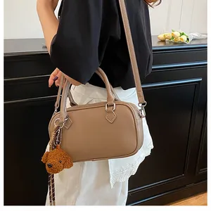 Brown litchi pattern Boston bag with cute dog pendant and adjustable strap details