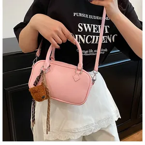 Pink Boston bag with litchi pattern featuring a cute brown bear charm on shoulder strap