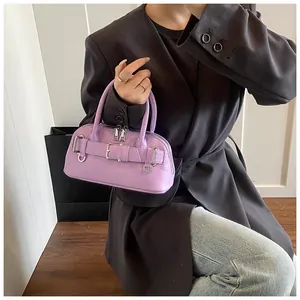 Detail of lavender shell handbag with metallic buckles and smooth synthetic leather texture