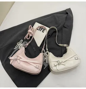 Detail view of crescent hobo bags with lace bows and decorative pearl strap charms