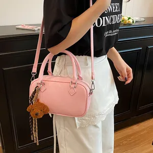 Pink litchi texture Boston bag with cute puppy pendant and woven tassel shoulder strap
