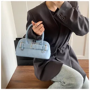 Detail of light blue leather shell bag with silver hardware and double zipper closure