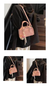 Multiple views of a pink Boston bag with embossed ATN letters and cute charms