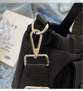 Detailed close-up of premium silver metal hook and D-ring on a black nylon bucket bag