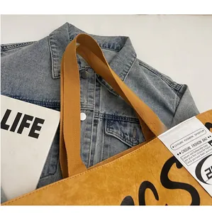 Detailed close-up of a mustard yellow DuPont paper tote bag with reinforced handles