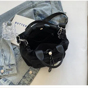 Top-down view of black nylon bucket bag interior with zipper pocket and shoulder strap
