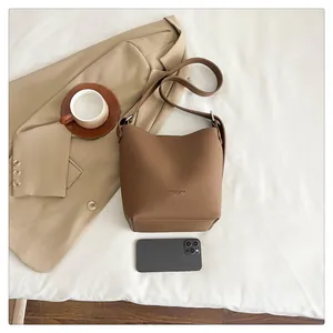 Detailed texture of brown litchi pattern leather bucket bag on a white sheet