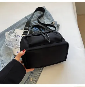 Close-up of lightweight black nylon bucket bag with decorative drawstring and strap